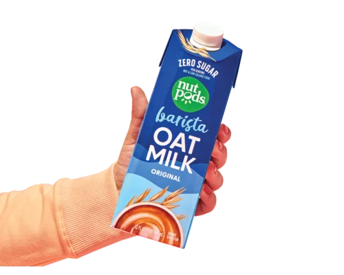 A hand holding a bottle of nutpods barista oatmilk