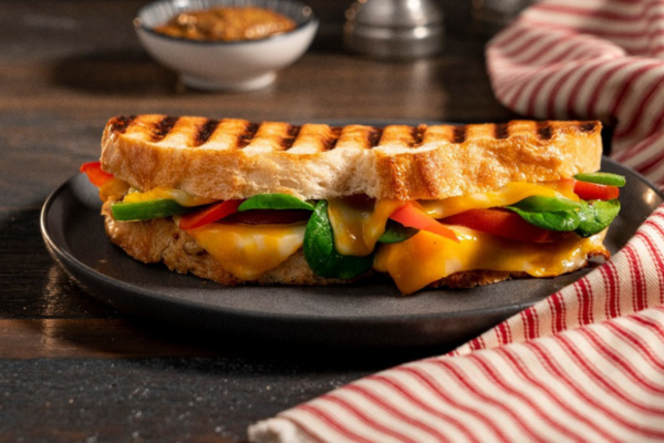 panini filled with veggies on a black plate